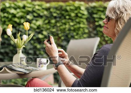 Caucasian woman using cell phone outdoors View Large Photo Image Picture - Caucasian woman using cell phone outdoors. Fotosearch
