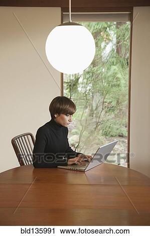 Caucasian woman using laptop on table View Large Photo Image Stock Image - Caucasian woman using laptop on table. Fotosearch