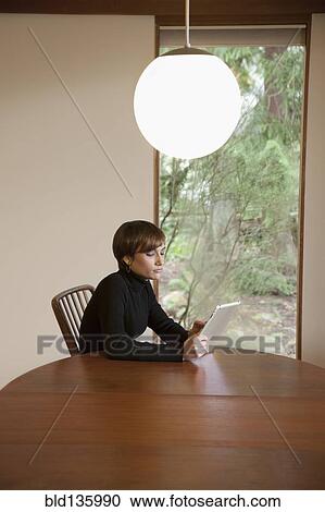 Caucasian woman using tablet computer at table View Large Photo Image Stock Image - Caucasian woman using tablet computer at table. Fotosearch