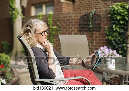 Caucasian woman using tablet computer outdoors View Large Photo Image Stock Image - Caucasian woman using tablet computer outdoors. Fotosearch