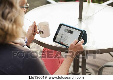 Stock Photo - Caucasian woman using tablet computer outdoors. Fotosearch