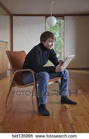 Caucasian woman using tablet computer in armchair View Large Photo Image Stock Photography - Caucasian woman using tablet computer in armchair. Fotosearch