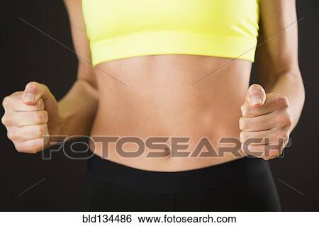 Caucasian woman with bare stomach clenching her fists View Large Photo Image Stock Photograph - Caucasian woman with bare stomach clenching her fists. Fotosearch
