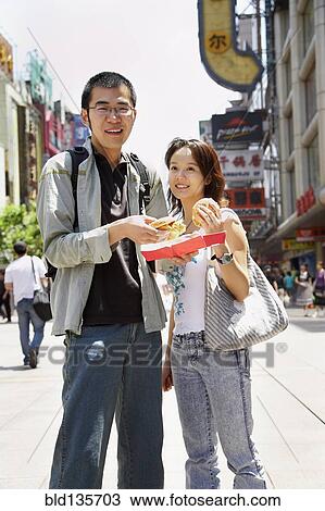 Chinese couple eating on city street View Large Photo Image Stock Image - Chinese couple eating on city street. Fotosearch
