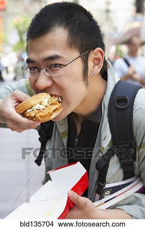 Chinese man eating on city street View Large Photo Image Picture - Chinese man eating on city street. Fotosearch