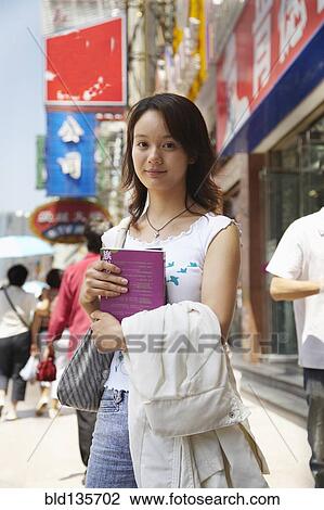 Chinese woman smiling on city street, Shanghai, China View Large Photo Image Stock Image - Chinese woman smiling on city street, Shanghai, China. Fotosearch