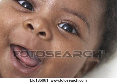 Stock Image - Close up of Black baby's smiling face. Fotosearch