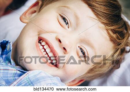 Stock Image - Close up of boy's smiling face. Fotosearch