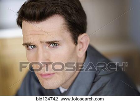 Stock Image - Close up of Caucasian man frowning. Fotosearch