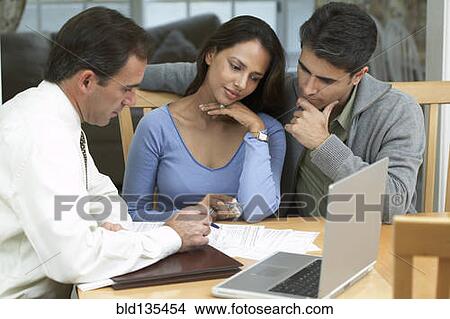 Couple and businessman examining papers View Large Photo Image Picture - Couple and businessman examining papers. Fotosearch