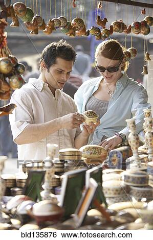 Stock Photograph - Couple buying food at outdoor market. Fotosearch