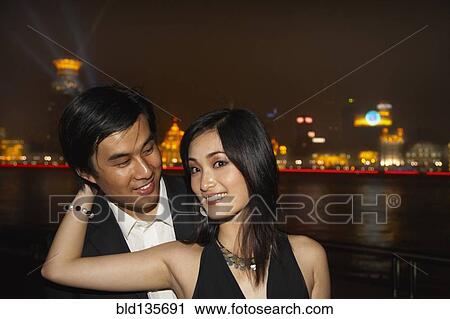 Couple by city skyline lit up at night, Shanghai, China View Large Photo Image Stock Image - Couple by city skyline lit up at night, Shanghai, China. Fotosearch