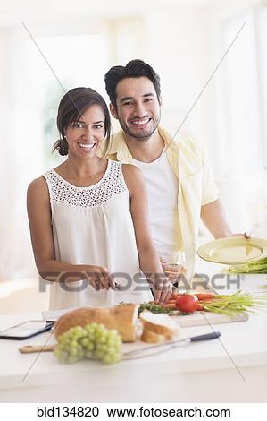 Couple cooking together in kitchen View Large Photo Image Stock Image - Couple cooking together in kitchen. Fotosearch