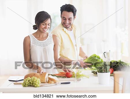 Couple cooking together in kitchen View Large Photo Image Stock Image - Couple cooking together in kitchen. Fotosearch