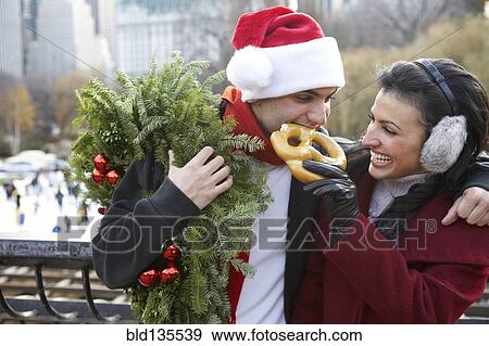 Stock Photo - Couple eating pretzel on city street. Fotosearch