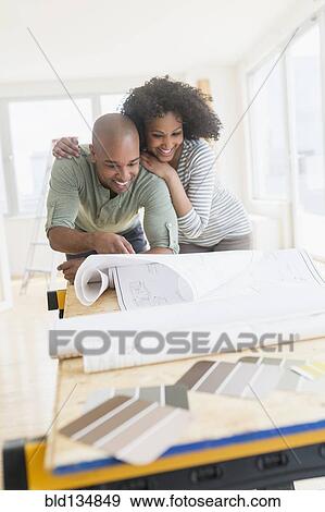 Couple examining blueprints of new home View Large Photo Image Stock Photo - Couple examining blueprints of new home. Fotosearch
