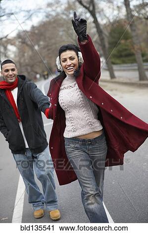 Couple hailing taxi in urban park View Large Photo Image Stock Image - Couple hailing taxi in urban park. Fotosearch