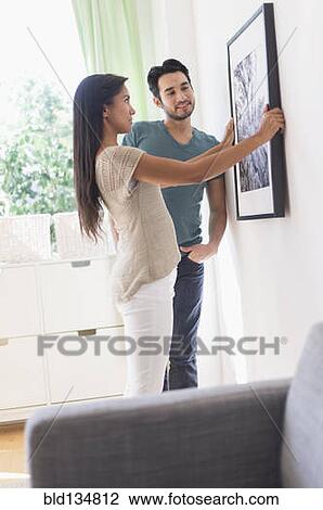 Couple hanging picture together View Large Photo Image Stock Image - Couple hanging picture together. Fotosearch