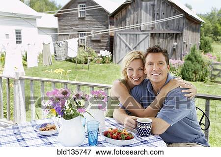 Stock Photo - Couple having coffee on patio. Fotosearch