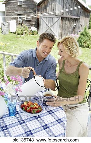 Stock Photo - Couple having coffee on patio. Fotosearch