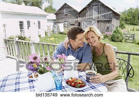 Couple having coffee on patio View Large Photo Image Stock Photo - Couple having coffee on patio. Fotosearch