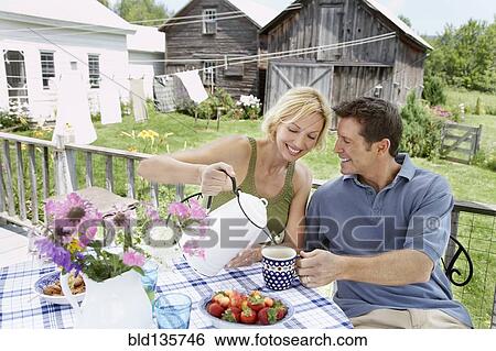 Stock Photograph - Couple having coffee on patio. Fotosearch