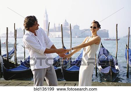 Couple holding hands on urban canal front, Venice, Veneto, Italy View Large Photo Image Stock Photo - Couple holding hands on urban canal front, Venice, Veneto, Italy. Fotosearch