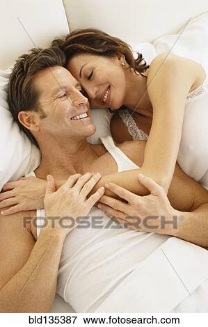 Couple hugging in bed View Large Photo Image Stock Photo - Couple hugging in bed. Fotosearch