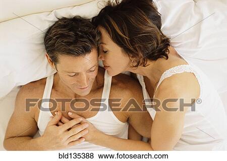 Stock Photo - Couple hugging in bed. Fotosearch