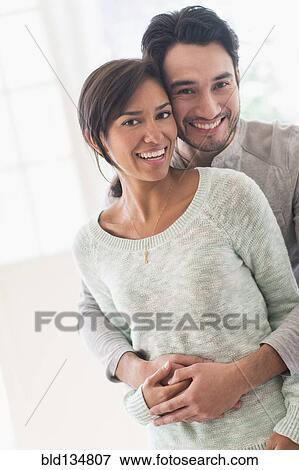 Stock Photo - Couple hugging indoors. Fotosearch