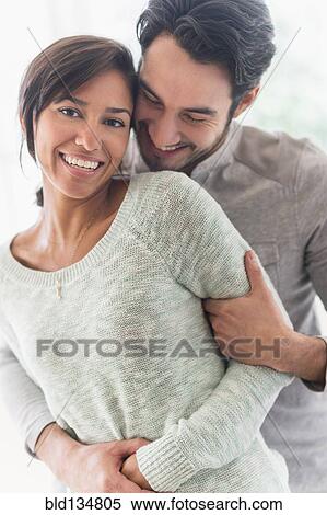 Stock Photography - Couple hugging indoors. Fotosearch