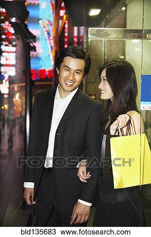 Couple on city street lit up at night, Shanghai, China View Large Photo Image Stock Image - Couple on city street lit up at night, Shanghai, China. Fotosearch