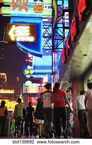 Couple on city street lit up at night, Shanghai, China View Large Photo Image Stock Image - Couple on city street lit up at night, Shanghai, China. Fotosearch