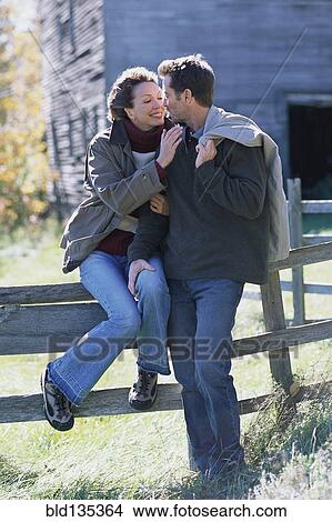 Picture - Couple relaxing together in rural landscape. Fotosearch