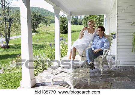 Stock Image - Couple relaxing together on patio. Fotosearch