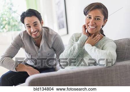 Picture - Couple relaxing together on sofa. Fotosearch