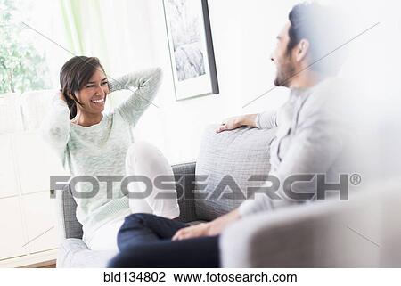 Couple relaxing together on sofa View Large Photo Image Stock Image - Couple relaxing together on sofa. Fotosearch