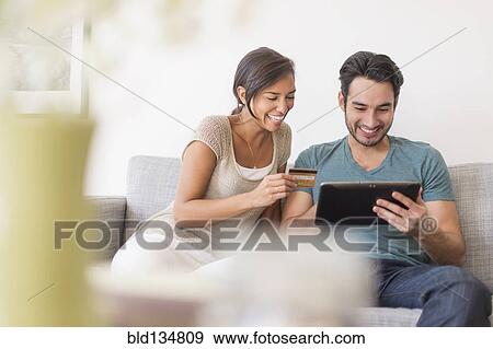 Couple shopping together on digital tablet View Large Photo Image Stock Photo - Couple shopping together on digital tablet. Fotosearch