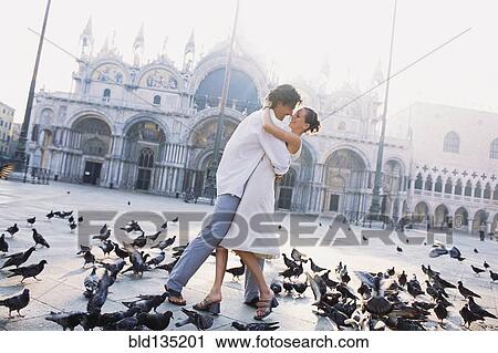 Couple surrounded by pigeons in St. Mark's Square, Venice, Veneto, Italy View Large Photo Image Stock Image - Couple surrounded by pigeons in St. Mark's Square, Venice, Veneto, Italy. Fotosearch