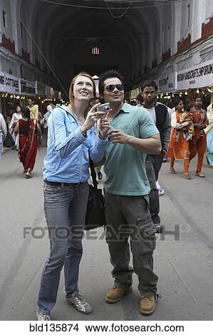 Picture - Couple taking pictures in market. Fotosearch
