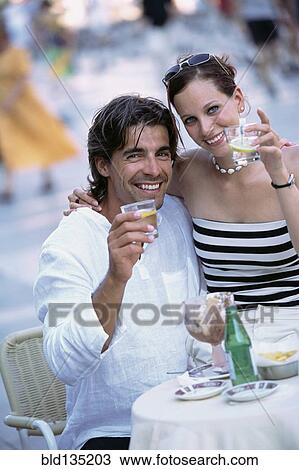 Couple toasting each other at sidewalk cafe View Large Photo Image Stock Image - Couple toasting each other at sidewalk cafe. Fotosearch