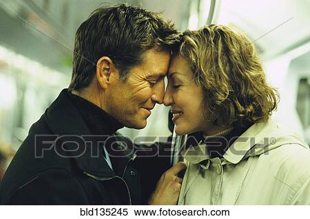 Stock Photography - Couple touching foreheads on subway. Fotosearch