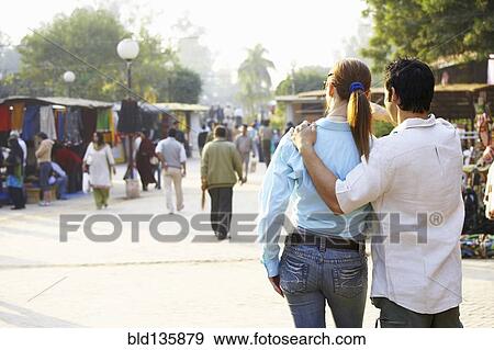 Couple walking in outdoor market View Large Photo Image Stock Photo - Couple walking in outdoor market. Fotosearch