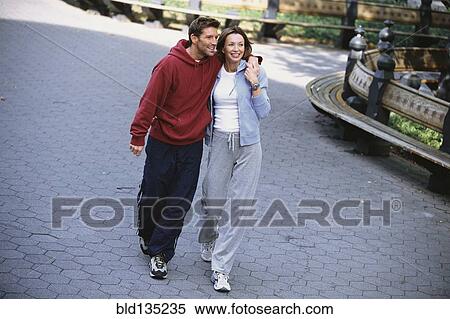 Couple walking in urban park View Large Photo Image Stock Photography - Couple walking in urban park. Fotosearch