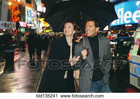 Couple walking on city street at night, New York City, New York, United States View Large Photo Image Stock Image - Couple walking on city street at night, New York City, New York, United States. Fotosearch