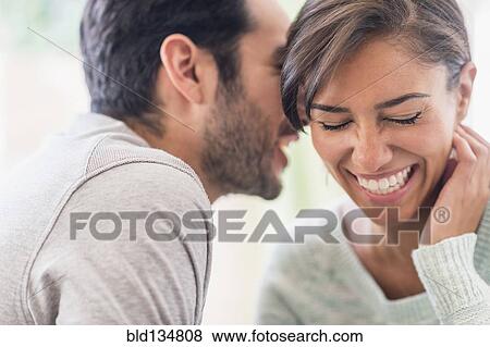 Couple whispering together indoors View Large Photo Image Stock Photo - Couple whispering together indoors. Fotosearch