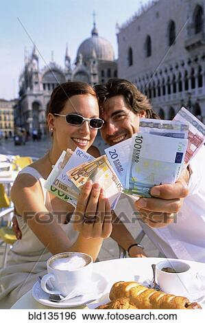Couple with wads of cash having breakfast at cafe View Large Photo Image Stock Photograph - Couple with wads of cash having breakfast at cafe. Fotosearch