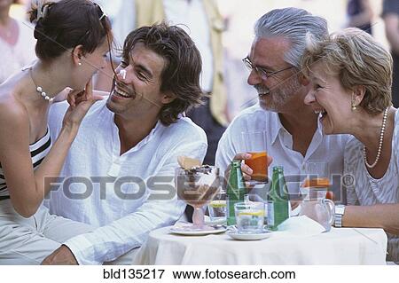 Stock Photo - Couples eating together at sidewalk cafe. Fotosearch