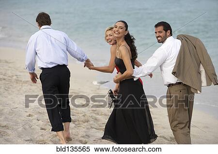 Couples walking together on beach View Large Photo Image Stock Photography - Couples walking together on beach. Fotosearch