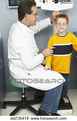Doctor measuring boy's height in office View Large Photo Image Stock Photo - Doctor measuring boy's height in office. Fotosearch